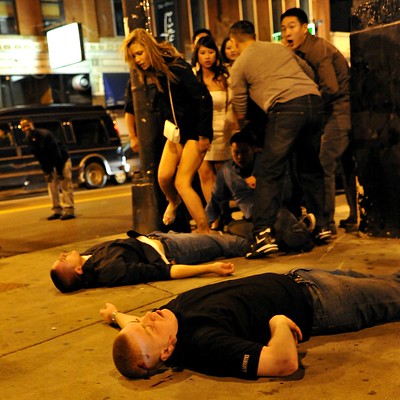 two men lay on the sidewalk barely conscious after a bar fight